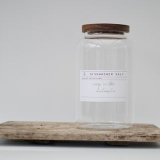 Three clear glass jars with wooden lids, labeled respectively for Dishwasher Pods, Dishwasher Salt, and Rinse Aid.