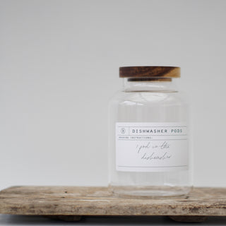 Three clear glass jars with wooden lids, labeled respectively for Dishwasher Pods, Dishwasher Salt, and Rinse Aid.