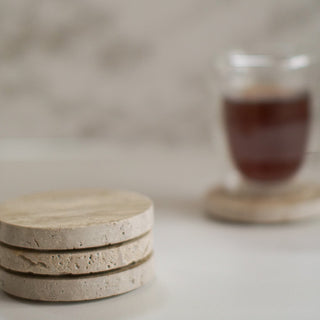 set if 3 travertine coasters with cup in the background