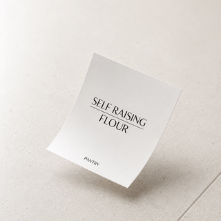 A single white square card or packet floating against a light warm beige background, printed with the words 'SELF RAISING FLOUR' and smaller 'PANTRY' text.