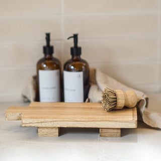 wooden footed paddle board with soap bottles in background