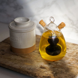 Butter container and glass bottle with oil on a wooden surface