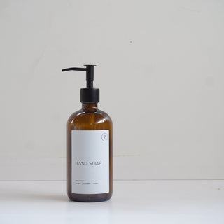 Amber glass bottle with black pump on a white background