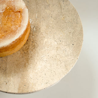 Close-up of a round stone surface with a piece of bread on it