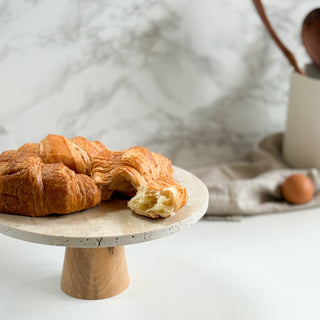 Croissants on a marble cake stand with a neutral background