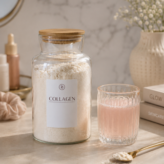 Collagen powder jar with a glass of pink drink on a marble surface.