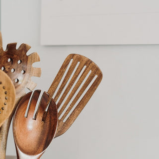 close up of wooden kitchen utensil set with ceramic pot